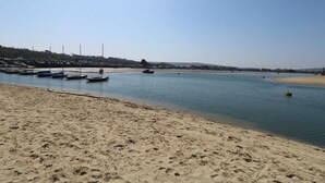 A sandy beach with boats docked in the water.