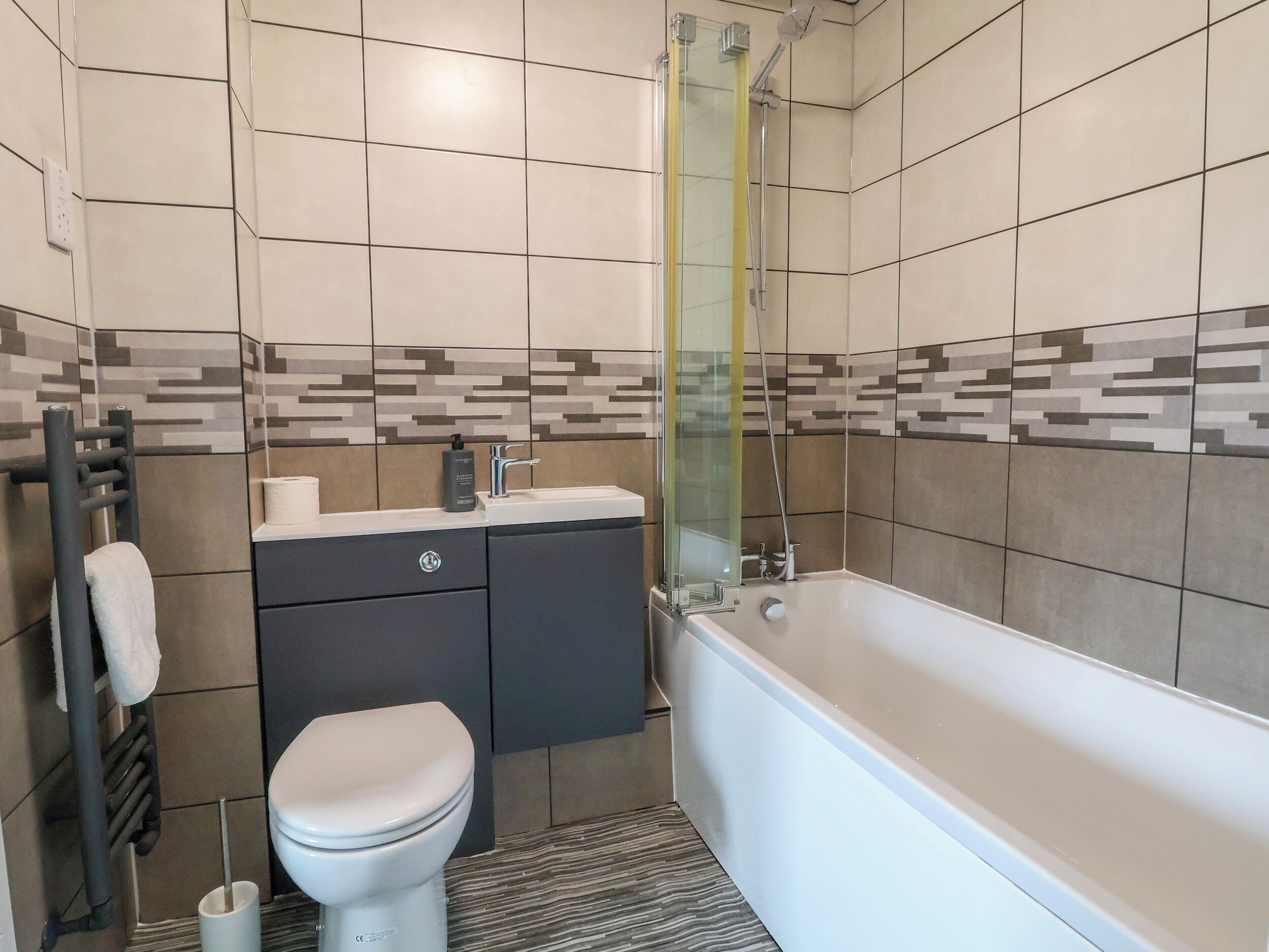 A modern bathroom with a toilet, sink, and bathtub.