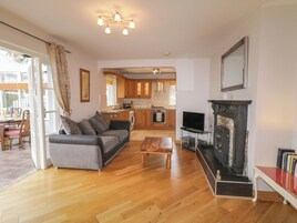 Una sala de estar con sofá, mesa de centro, chimenea y mueble para televisión.