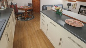 Una cocina con comedor, suelo de madera y tragaluz.