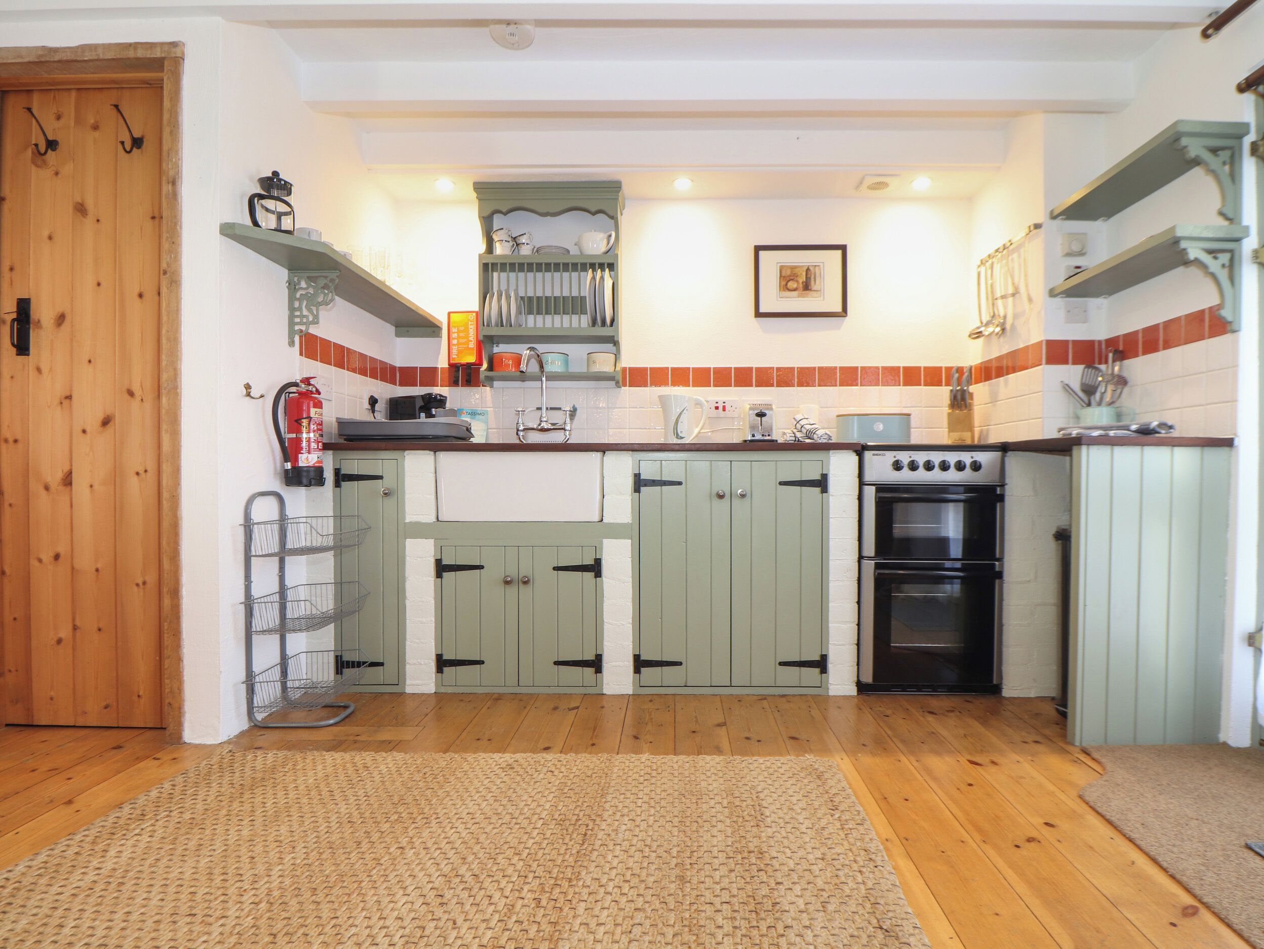 A compact kitchen with wooden cabinets, a built-in oven, and a small countertop.