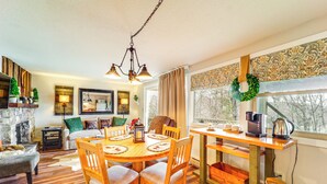 A cozy living room with a fireplace, a dining area with a wooden table and chairs, and a kitchen area with a coffee maker and kettle. - Hike, Sip & Stay Awhile! Sugar Mountain Getaway (Banner Elk)