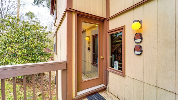 A wooden house with a brown door, a small porch, and a window with a light fixture. - Hike, Sip & Stay Awhile! Sugar Mountain Getaway (Banner Elk)