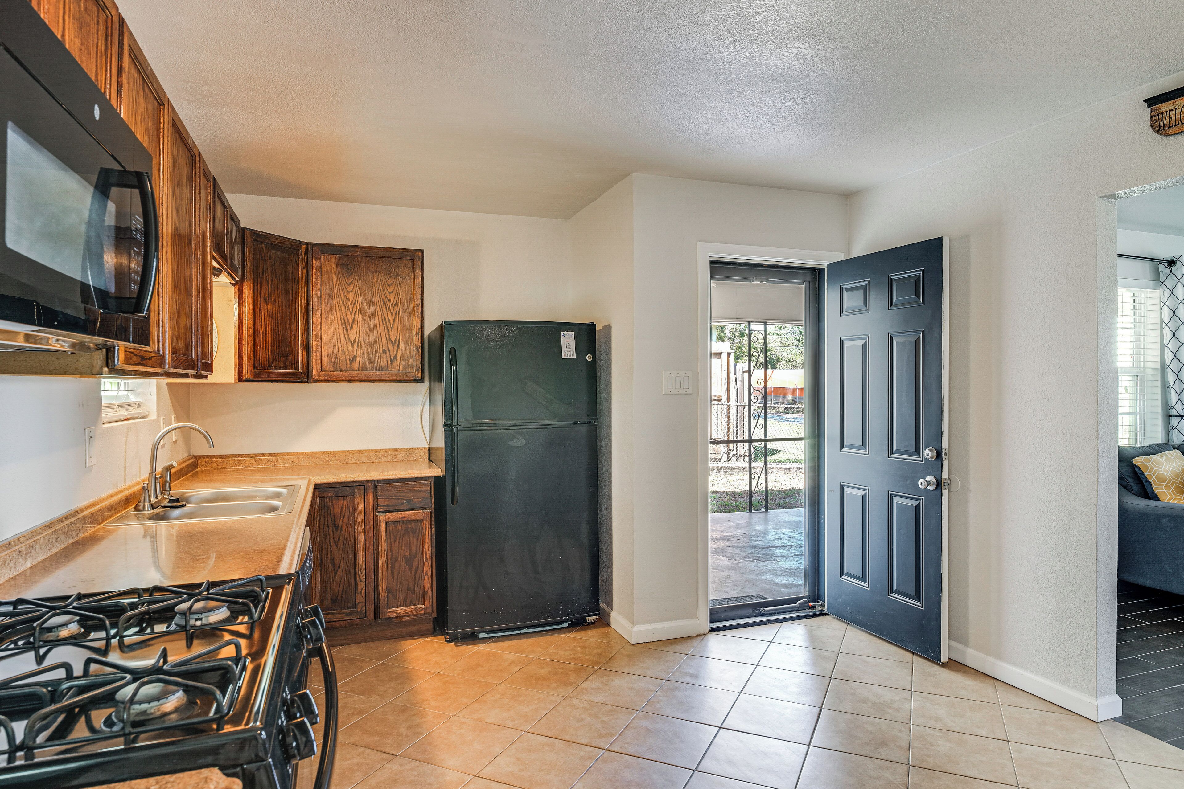 A compact kitchen with a gas stove, a microwave, and a refrigerator.