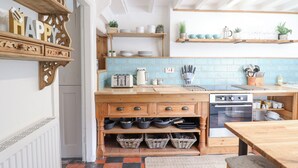 A kitchen with wooden cabinetry, a tiled backsplash, and various kitchen appliances.