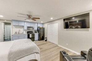 A compact bedroom with a bed, a ceiling fan, and a small seating area. - Private Yard: Pet-friendly Studio in New Boston! (New Boston)