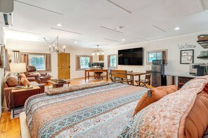 A spacious living area with a large bed, a sofa, a dining table, and a TV. - 3 Mi to Dtwn Greer: Mountain-view Home! (Greer)