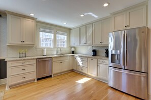 A spacious kitchen with white cabinets, stainless steel appliances, and a wooden floor. - 3 Mi to Dtwn Greer: Mountain-view Home! (Greer)