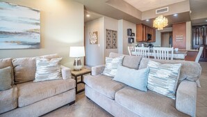Ein Wohnzimmer mit zwei Sofas, einem Beistelltisch, einer Lampe und einem Bild an der Wand.