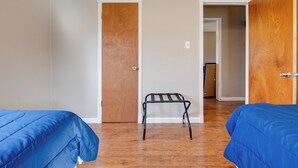 A room with two beds, wooden doors, and a metal bench. - 3 Mi to Dtwn Denton: Getaway w/ Furnished Patio! (Denton)