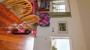 Una sala de estar acogedora con una mesa de comedor de madera, sillas, una chimenea y una pared de piedra.