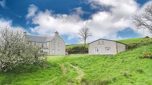 A large house with a paved driveway leading to a grassy area. - Narrow Gauge Cottage (Ballymoney)