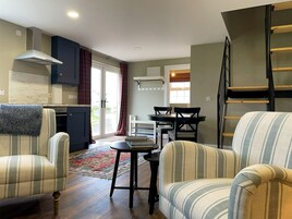 Un espacio habitable compacto con cocina, comedor y un entrepiso con cama.