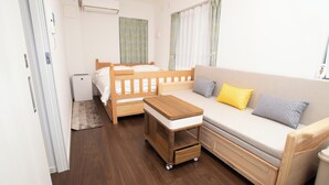 A compact room with a wooden bed, a sofa, a small table, and a cart. - Numabuki New Boutique Cozy Apartment，Private Bathroom ，High-quality Bedding (中野区沼袋)