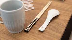 A wooden table with a white ceramic mug, chopsticks, and a white spoon. - Numabuki New Boutique Cozy Apartment，Private Bathroom ，High-quality Bedding (中野区沼袋)