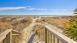 A wooden boardwalk leading to a beach with clear skies. - Scenic Oceanfront Condo in Myrtle Beach! (Myrtle Beach)