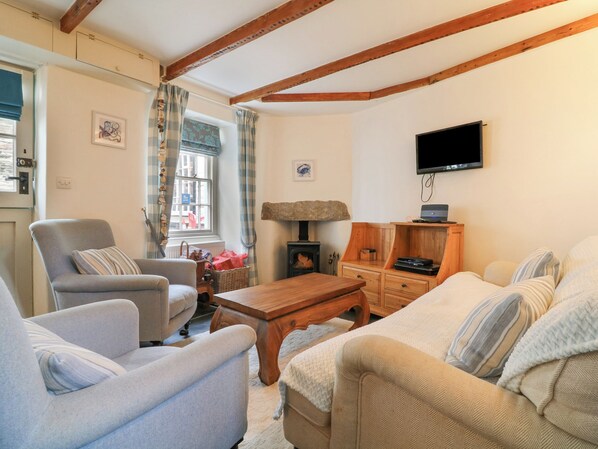 Una sala de estar acogedora con chimenea, muebles de madera y televisor.