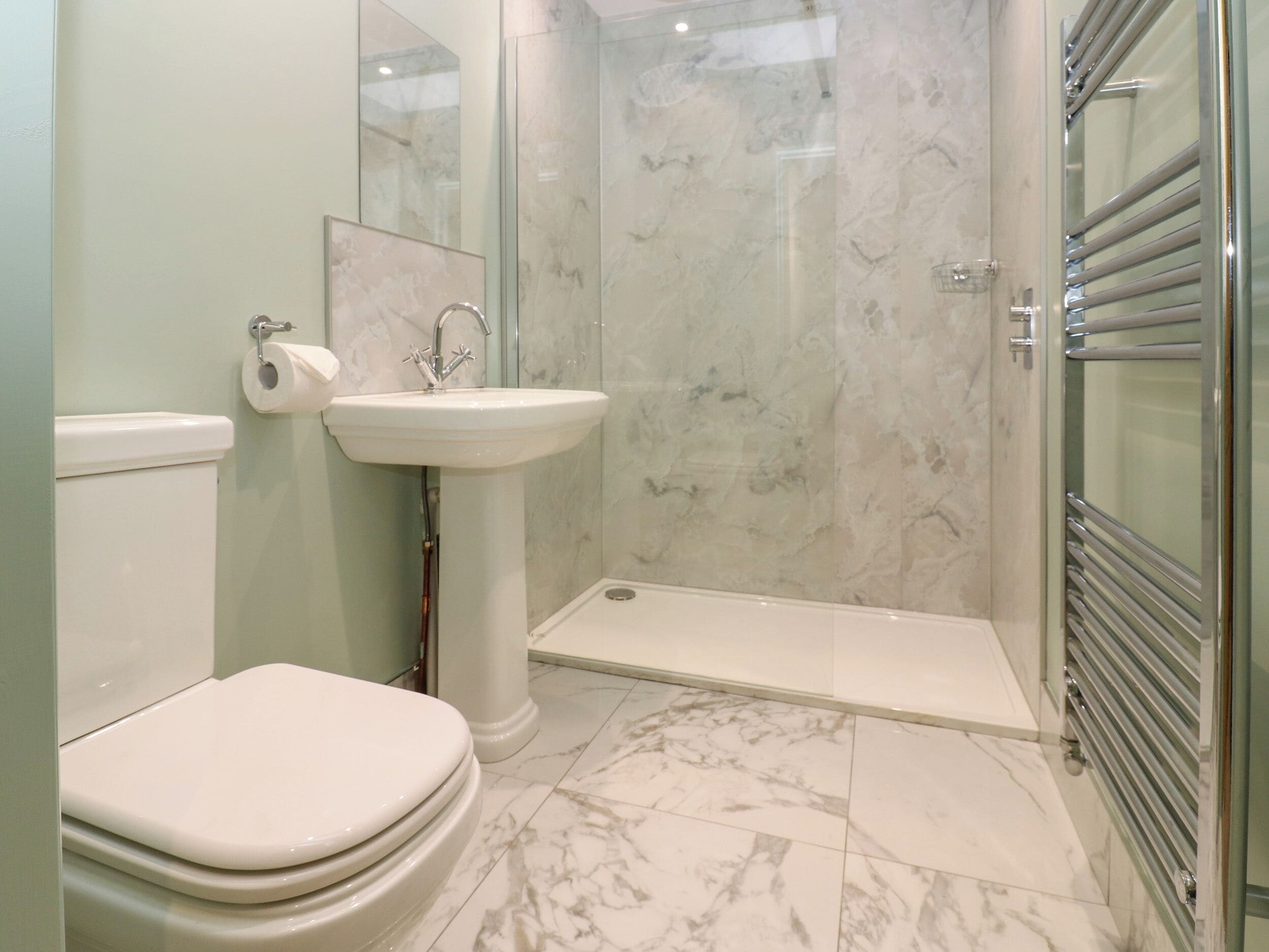 Een badkamer met toilet, wastafel en douche.