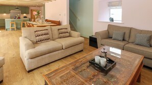A spacious living area with a sofa, a coffee table, and a dining table.