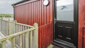 A red building with a black door and a window displaying the name "MALLARD". - Mallard Lodge (Galston)