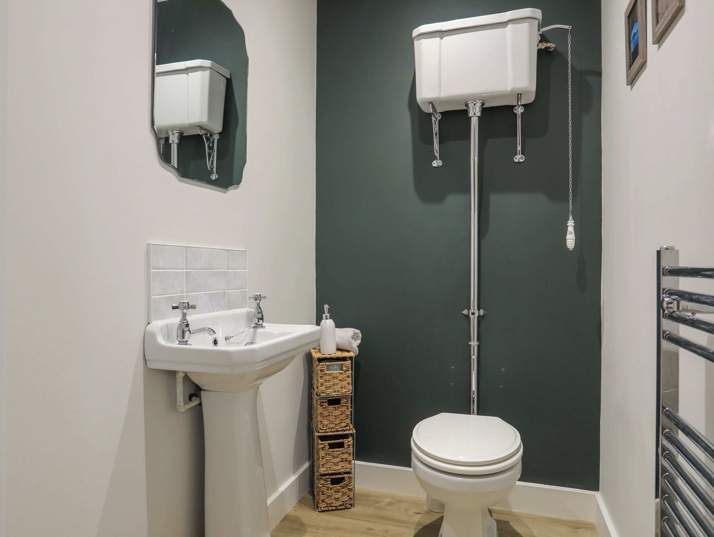 Une salle de bain avec un lavabo blanc, des toilettes et un miroir.