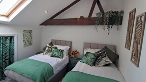 Un dormitorio con dos camas, un tragaluz y vistas al exterior.