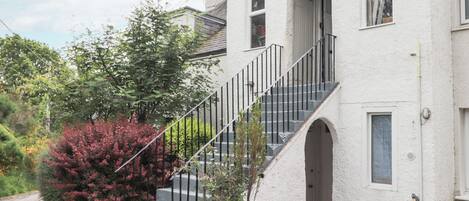A white building with a staircase leading to the entrance.