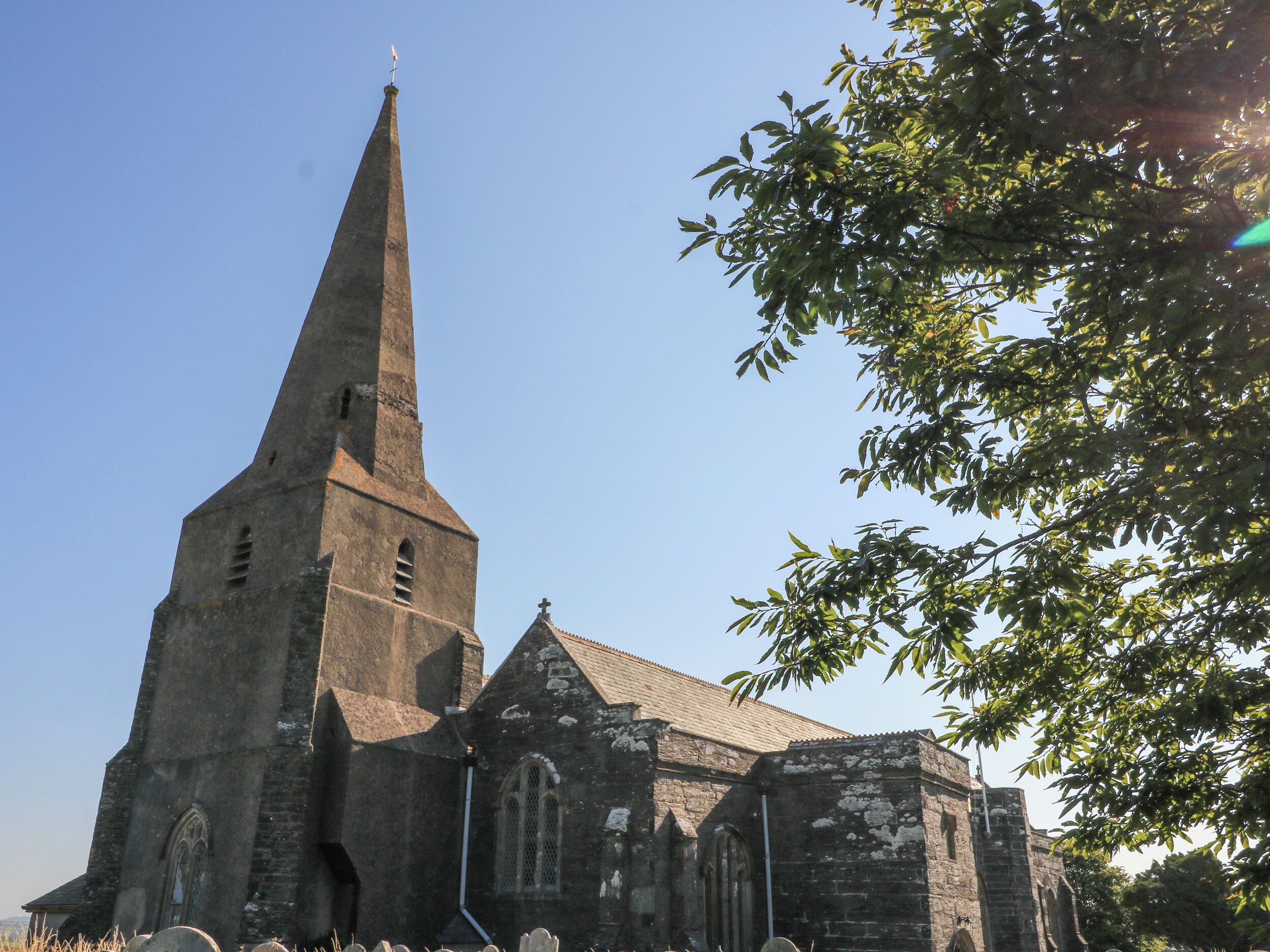 A church with a tall, pointed steeple and a traditional stone facade.