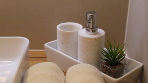 A bathroom with a white sink, two speckled soap dispensers, and a small potted plant. - Vienne Prime Apartments (Vienna)