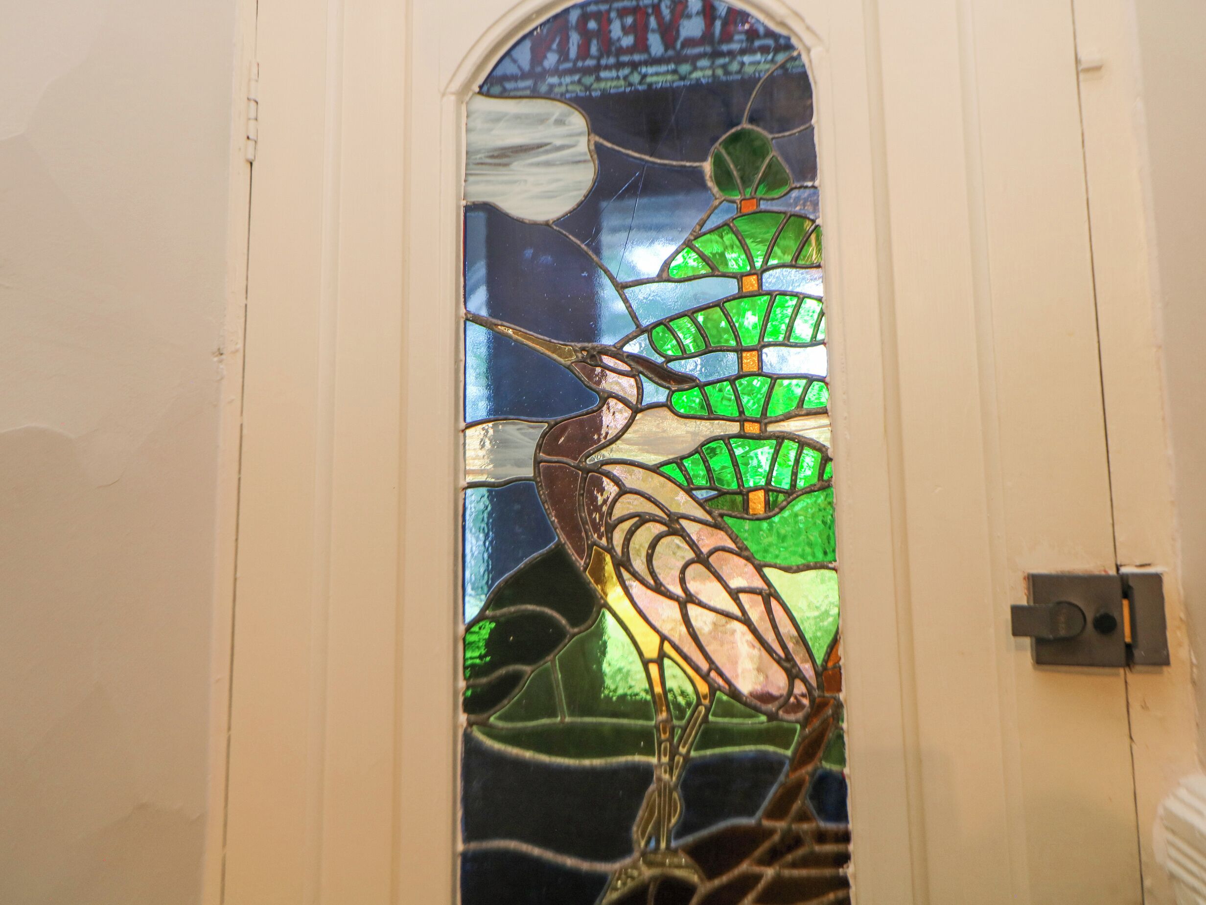 Una ventana de vitral con un diseño de pájaro.