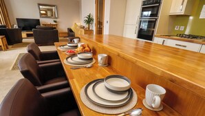 A dining area with a wooden table set for four, equipped with plates, bowls, and cutlery. - 43A Quay Street (Scarborough)