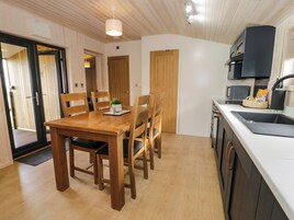 Una cocina compacta con una mesa de comedor de madera, sillas y una encimera blanca.