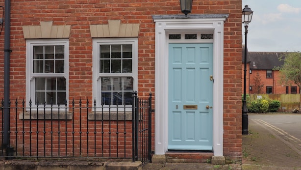 A red brick building with two windows and a light blue door. - 8 Nicholas Court (Chester)