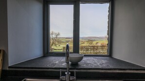 A kitchen with a double sink and a window overlooking a rural landscape. - Fell View House (Kendal)