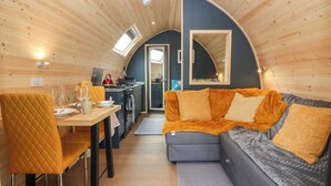 Un interior moderno y compacto con zona de comedor, kitchenette y espacio de estar.