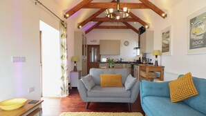A cozy living room with a grey sofa, a blue sofa, and a yellow rug.