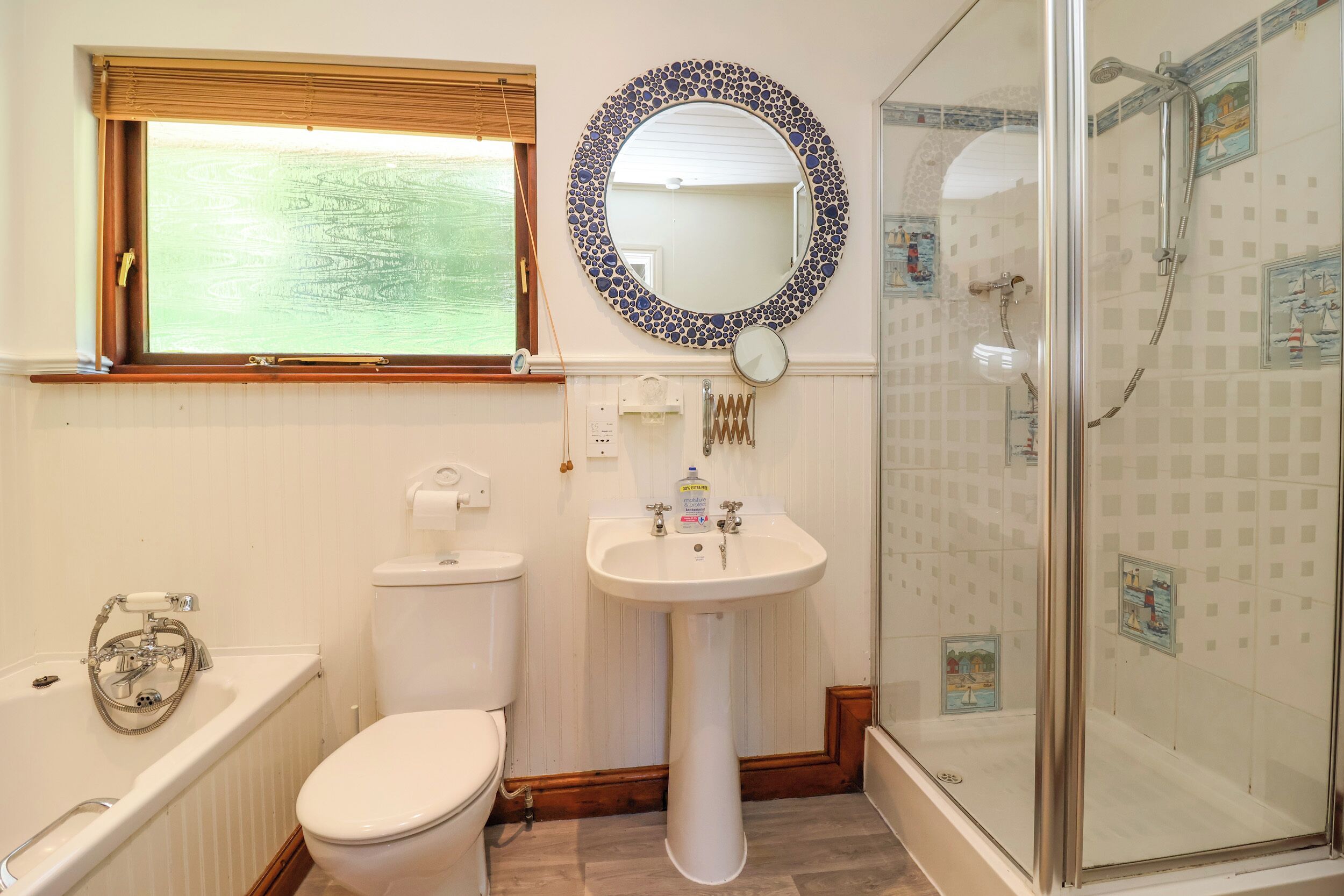 A bathroom with a toilet, sink, bathtub, and a shower.