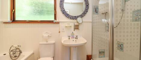 A bathroom with a toilet, sink, bathtub, and a shower.