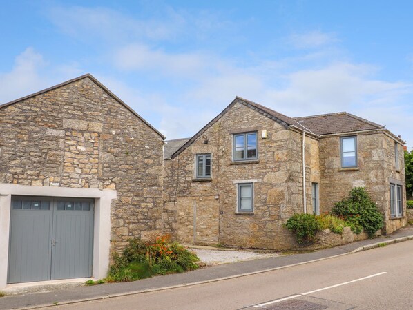 A stone building with a garage and two windows. - Nancherrow Studio (Penzance)