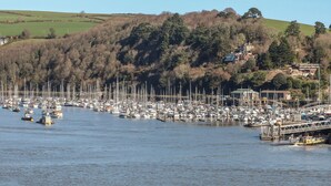 A marina with numerous boats docked, surrounded by hills and a few buildings. - Flat 2 Beechcroft (Dartmouth)