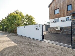 Ein modernes Gebäude mit Holzfassade, weißer Außenwand und steinernen Sockel.
