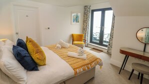 A bedroom with a bed, a chair, a desk, and a window. - Amelia's Point (St Ives)