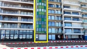 En bygning med flere etager og en iøjnefaldende grøn og gul facade, sandsynligvis et hotel eller et lejlighedskompleks.