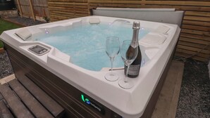 Un jacuzzi con dos copas y una botella de champán.
