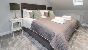 A bedroom with a bed, nightstands, a window, and a radiator. - The Bungalow at 46 Church St (Chorley)