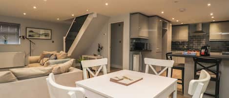 A modern kitchen with a microwave, a coffee machine, and a box of baking soda on the counter.