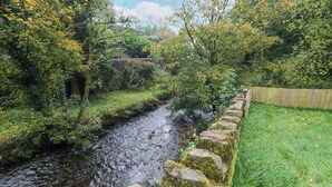 A narrow stream with a stone wall on one side and a grassy area on the other. - Blue Ron's (High Peak)