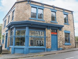 A corner building with a stone facade and blue trim. A sign indicates it is a tea shop.