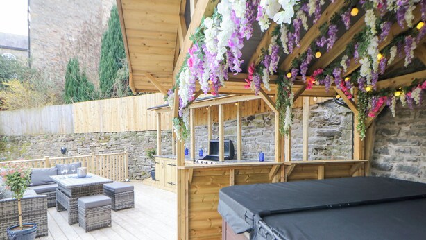 A wooden deck with outdoor seating, a barbecue area, and a hot tub. - Blue Ron's (High Peak)