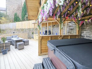 A wooden deck with outdoor seating, a barbecue area, and a hot tub. - Blue Ron's (High Peak)